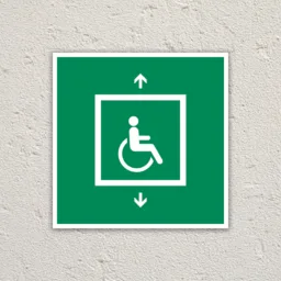 Green evacuation for people unable to use stairs sign sign on a cream painted wall.