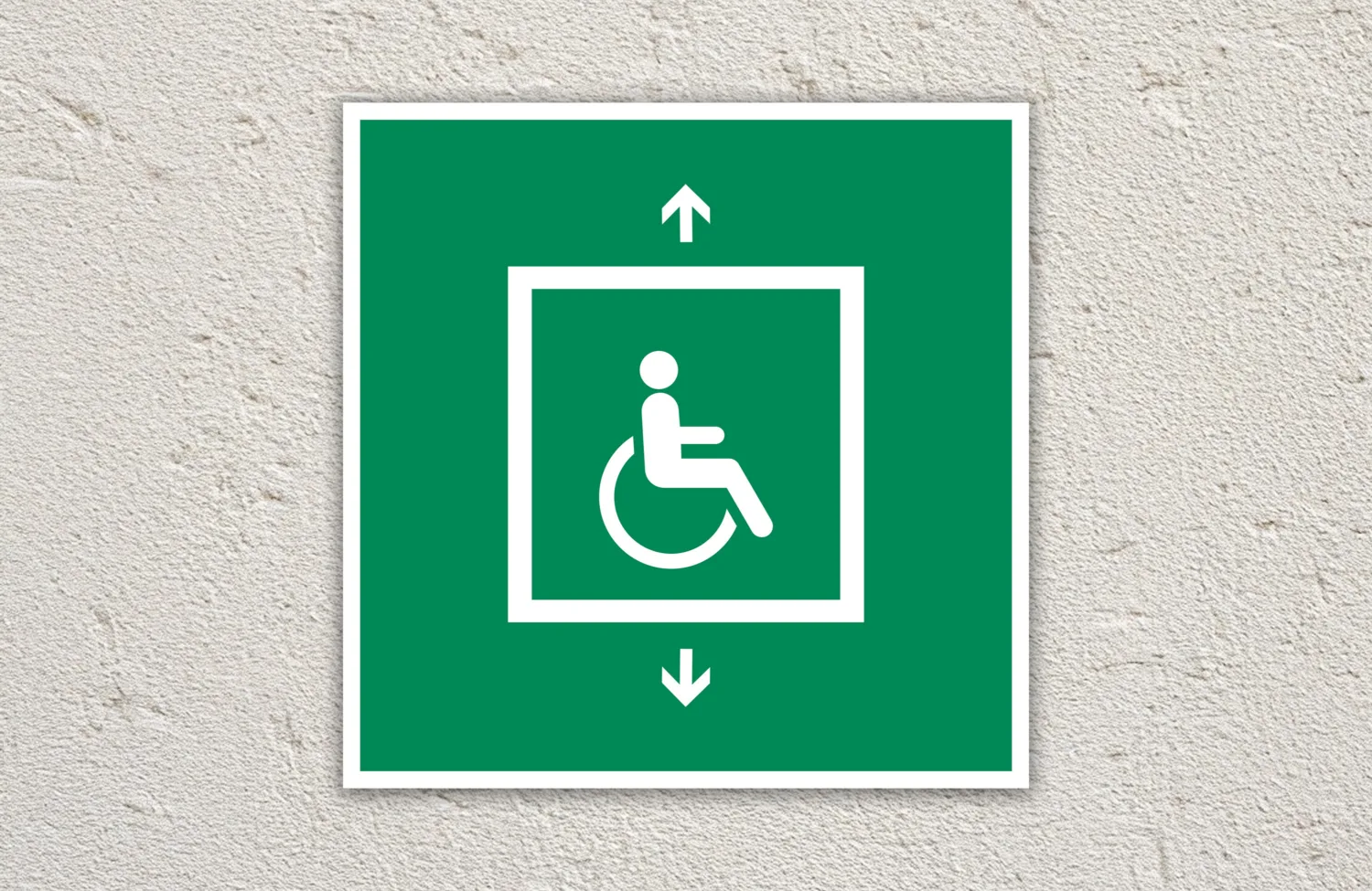 Green evacuation for people unable to use stairs sign sign on a cream painted wall.