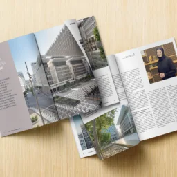 An open magazine on a wood surface showing an article entitled "Landmark partnership, landmark results", the opposite page features a photo of Bysshe Wallace.