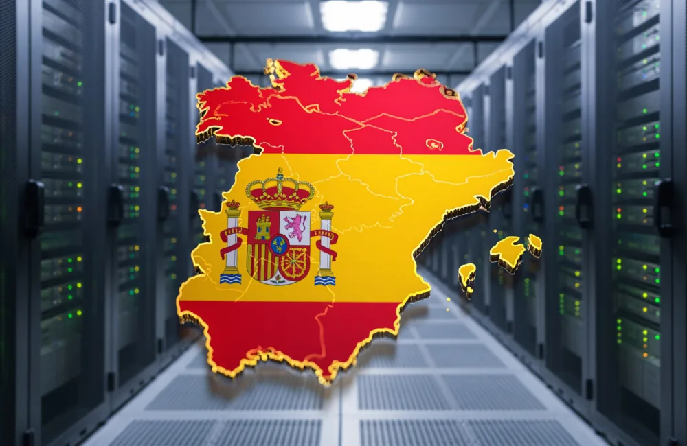 Rows of server racks in a data centre with a digitally superimposed outline map of Spain filled with Spanish flag colours and emblem in the centre.