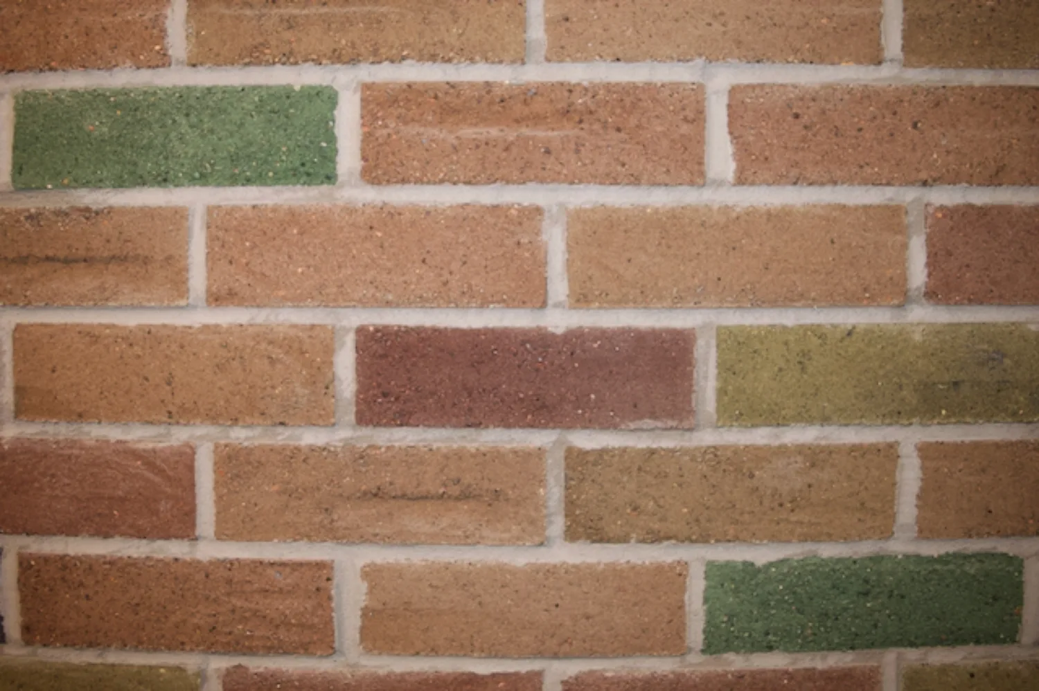 Close-up image of a brick wall displaying standard orange bricks along with multicoloured K-Briqs