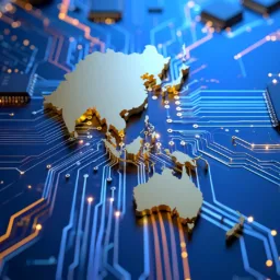 A close-up of a blue circuit board with gold pathways and multiple black microchips. At the centre, a raised gold map of APAC is integrated into the board.