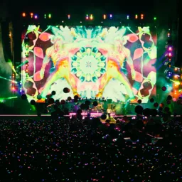 Overlooking the crowd at a Coldplay concert and the brightly lit colourful stage