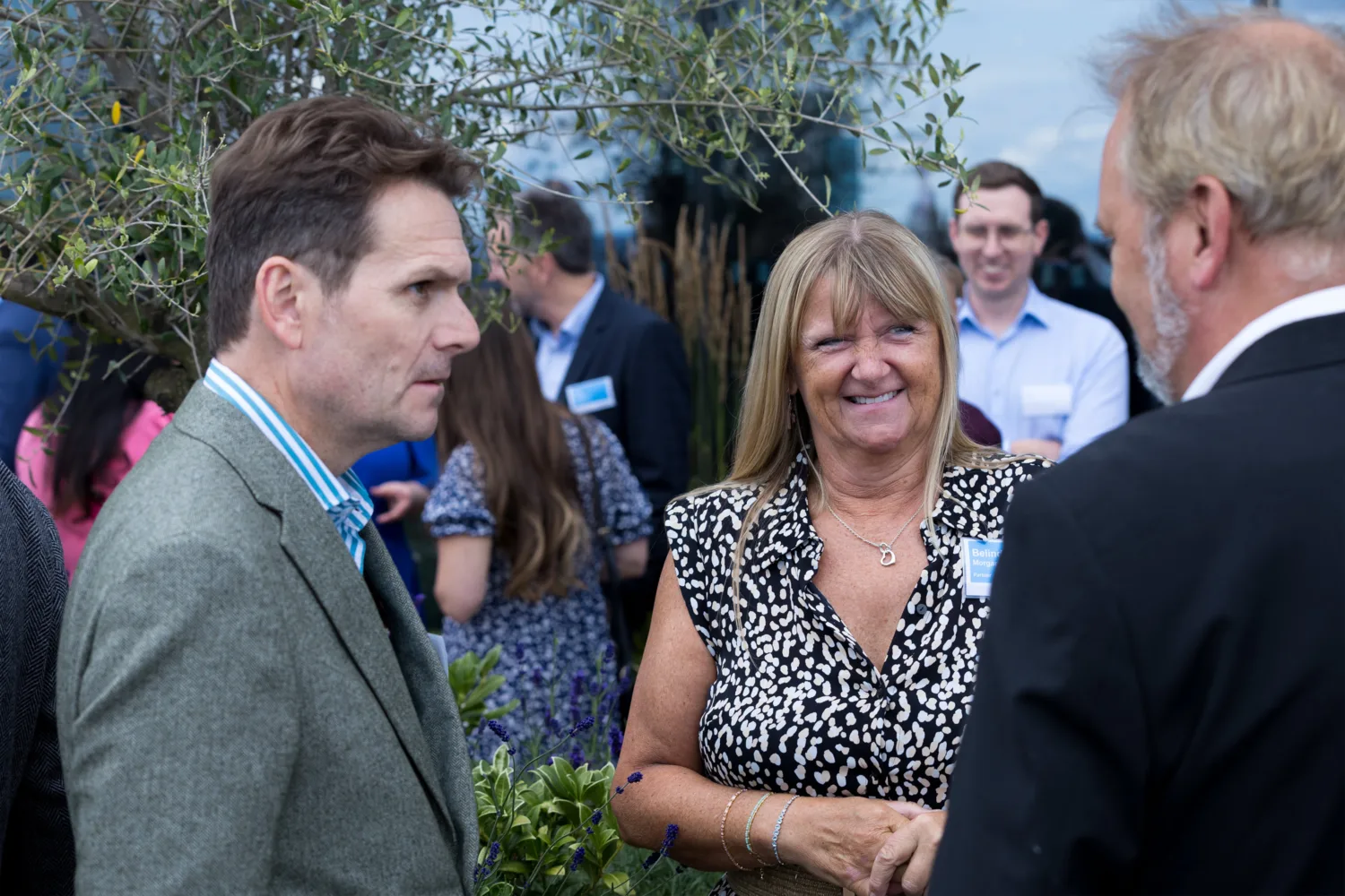 Three people engaged in conversation on the outdoor terrace