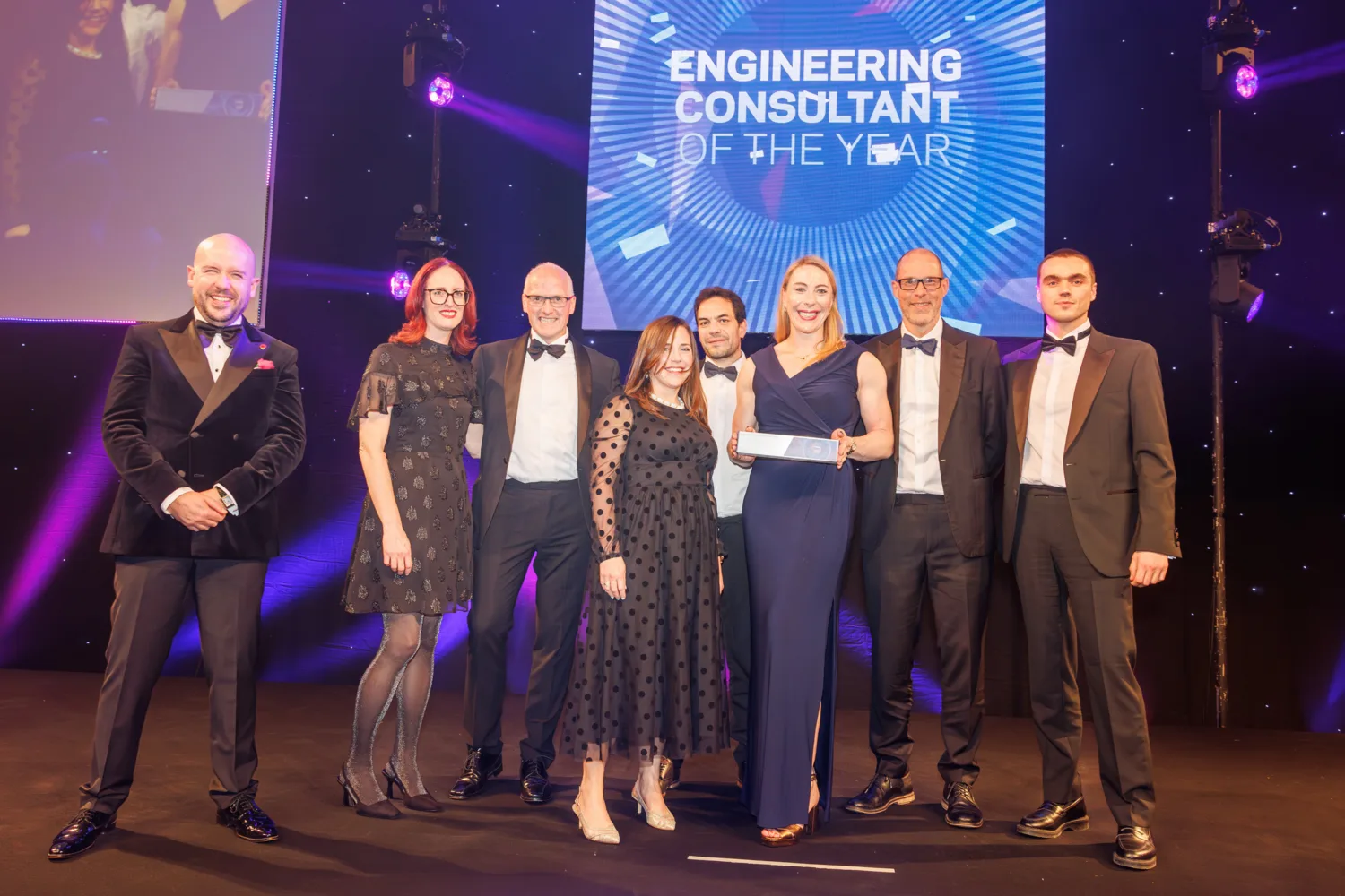 Cundall team on stage receiving the award in front of a large Engineering Consultant of the year screen