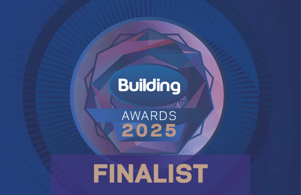 Circular graphic with geometric pattern and text 'Building Awards 2025' in the centre. Below is a bold banner reading 'FINALIST'. Background is dark blue with radiating lines.