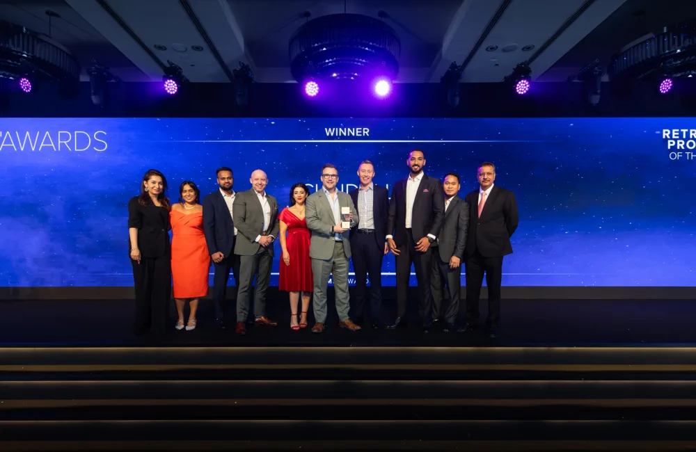 Ten people standing on a stage in front of a backdrop displaying “Mechanical Electrical Plumbing AWARDS,” “RETROFIT PROJECT OF THE YEAR,” and “WINNER”; posed for a group photo at an award ceremony.
