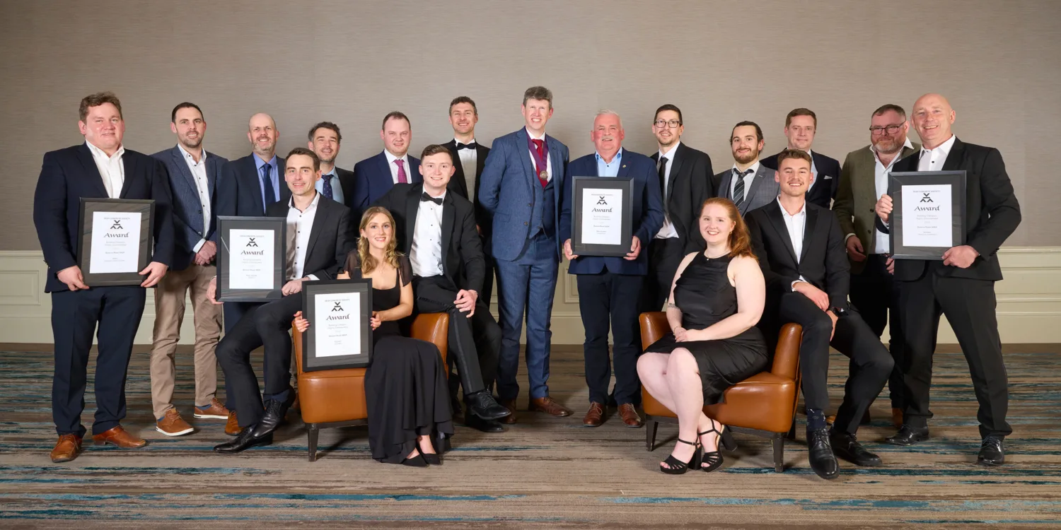 Award winning delegates standing in a room holding certificates