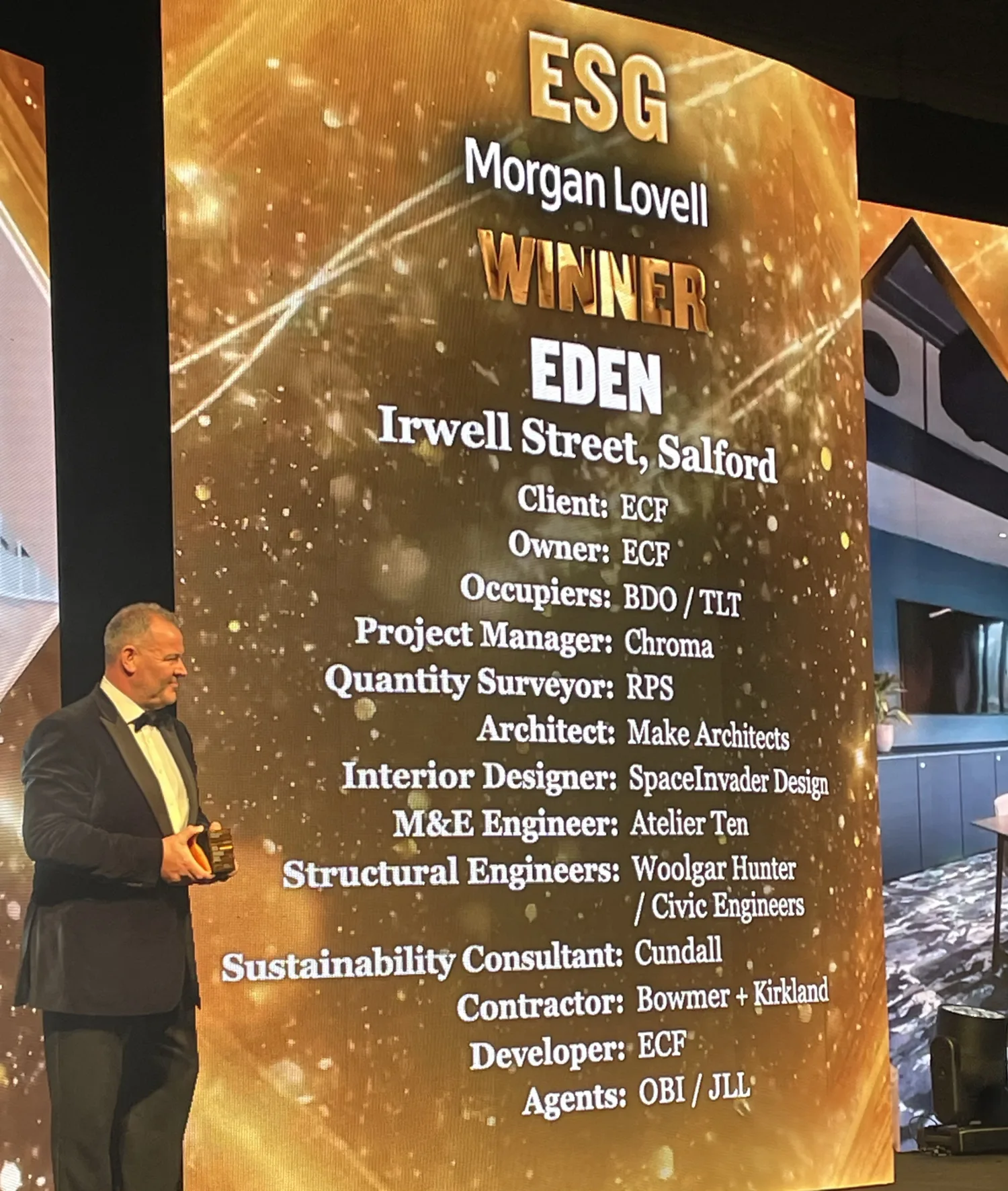 BCO National Awards 2025 stage with presenter and screen information on the project