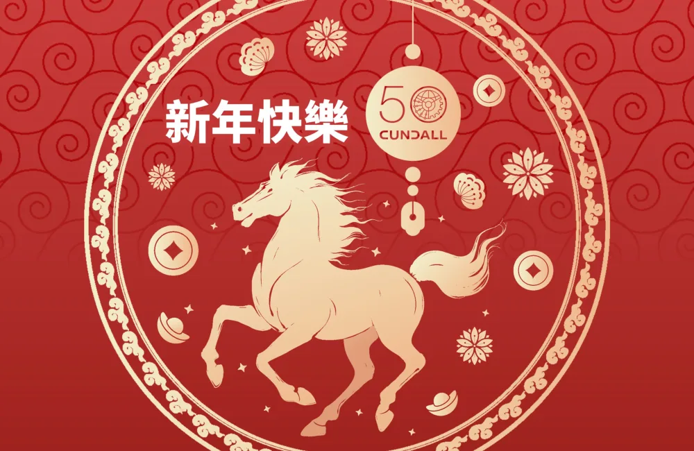 A red decorative graphic featuring a circular gold design with a horse at the center, surrounded by floral and geometric motifs.