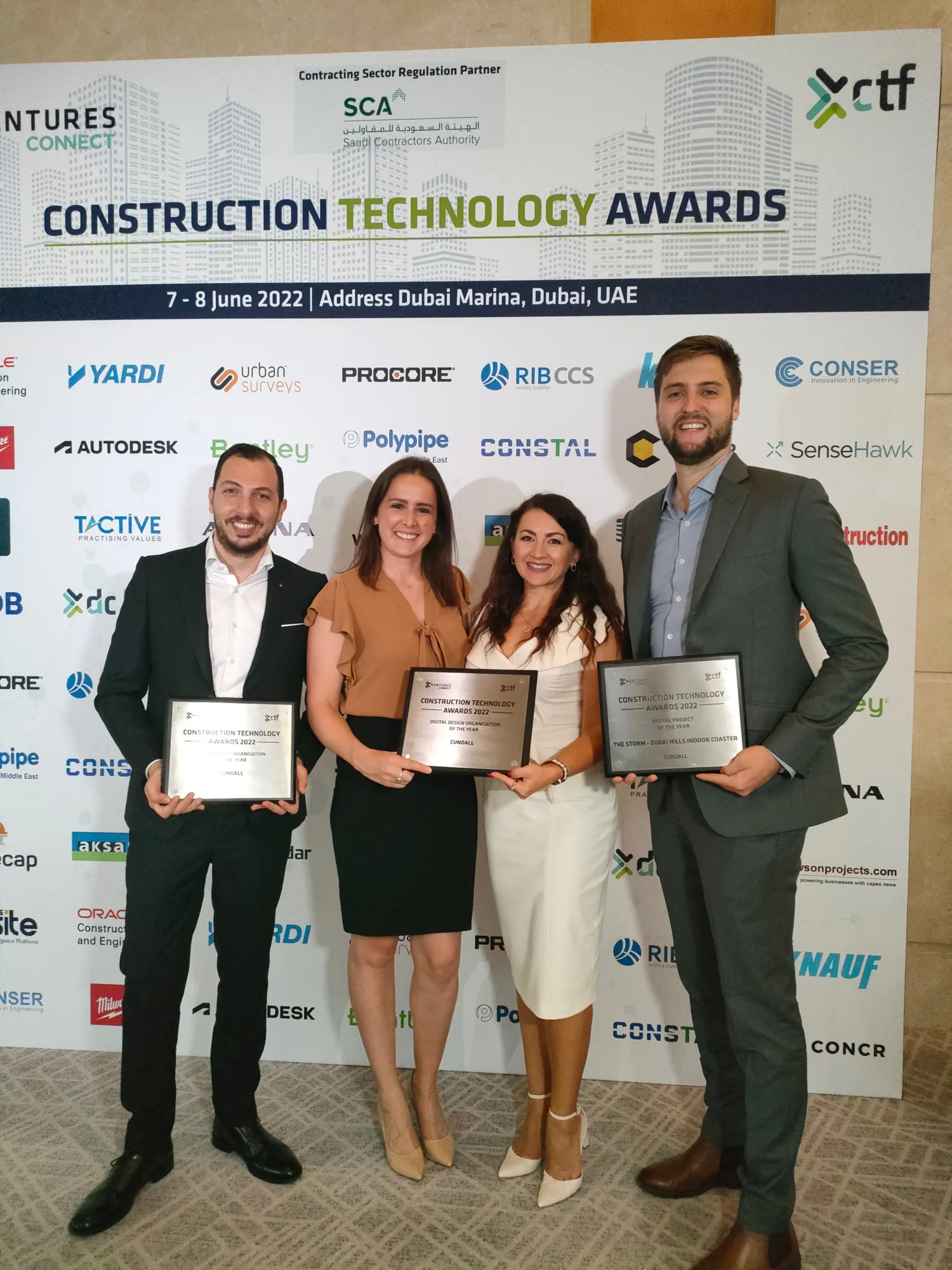 Our Cundall MENA colleagues posing for a photo while holding the 3 awards we won