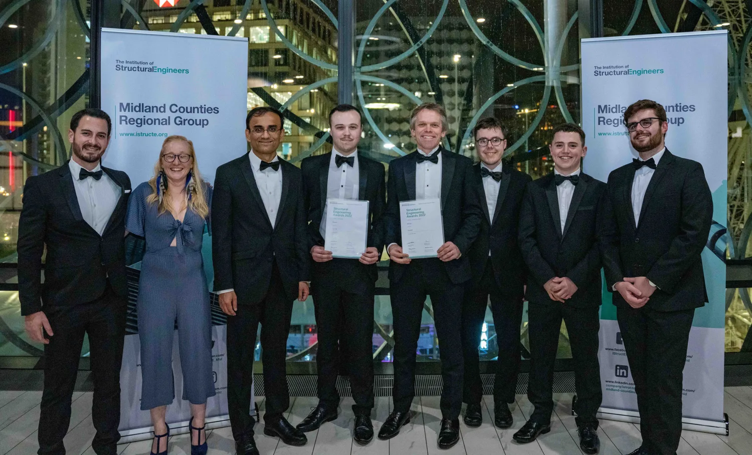 Group of people including Cundall's Alex Carter holding up their awards certificates
