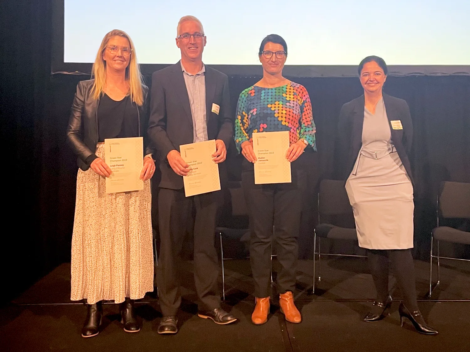 Madlen on stage with her certificate, 2 other winners and the presenter
