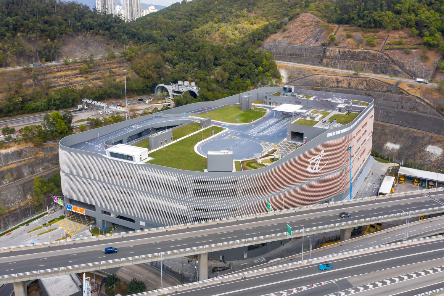 Arial view of the Vehicle Examination Centre showing green roof with highway in forground