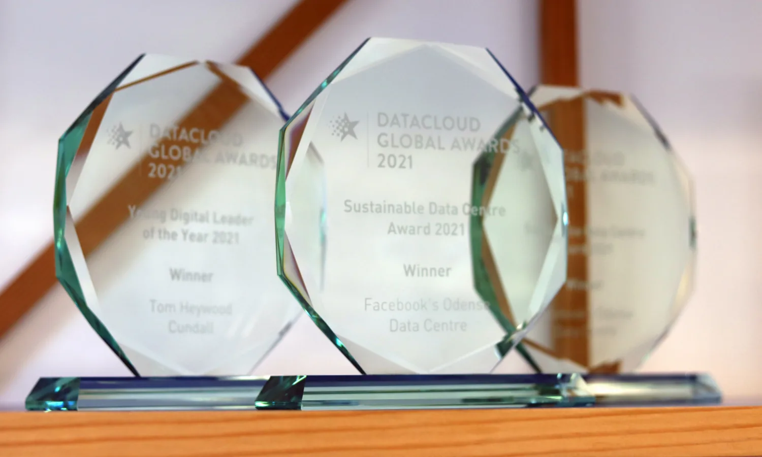 3 glass trophys sat on a wooden shelf