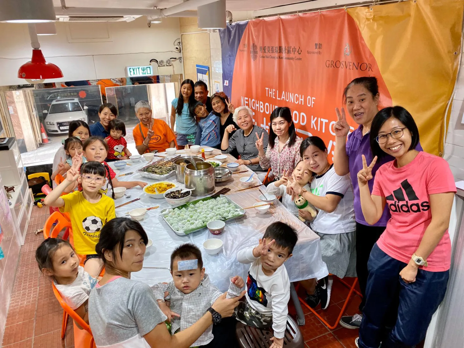 Families sat around a large table with food in the centre