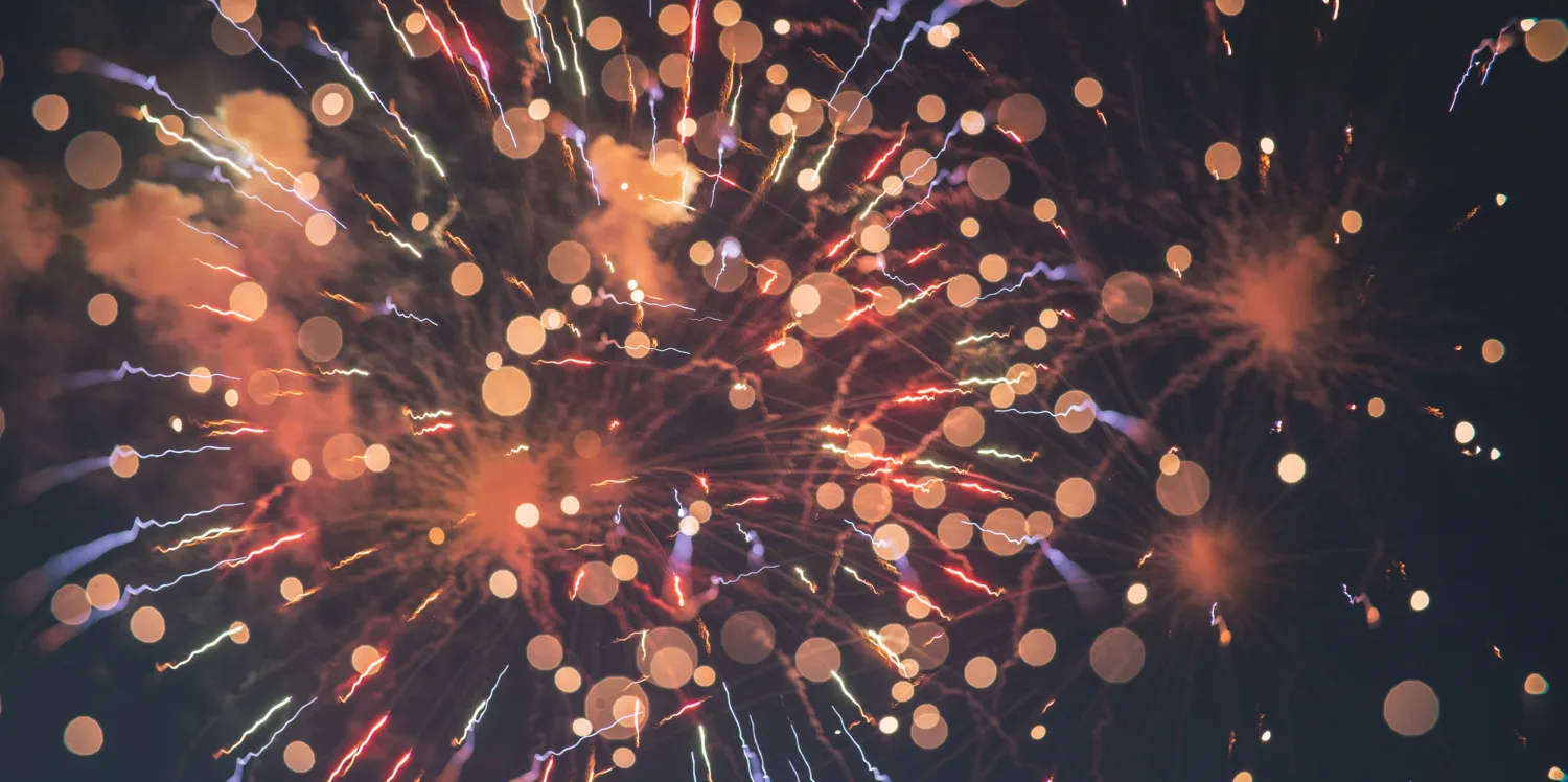 Orange and purple firework against a black sky background