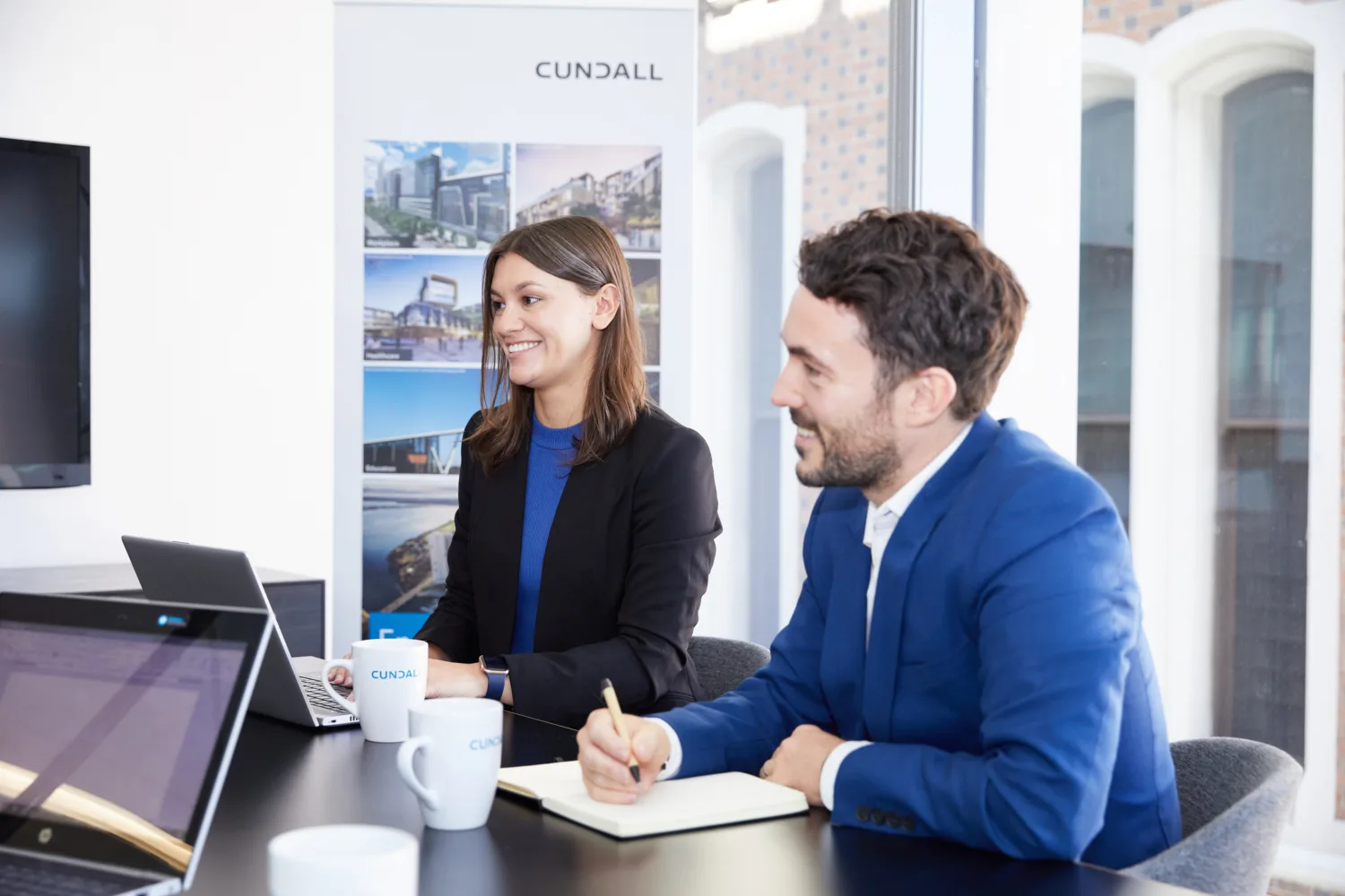 Cundall Perth meeting room with staff sitting with laptop and pads