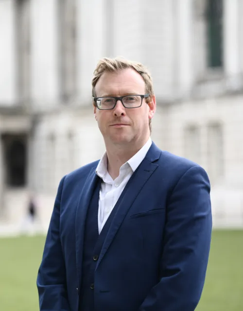 Ruairi Dempsey with white building background and grass