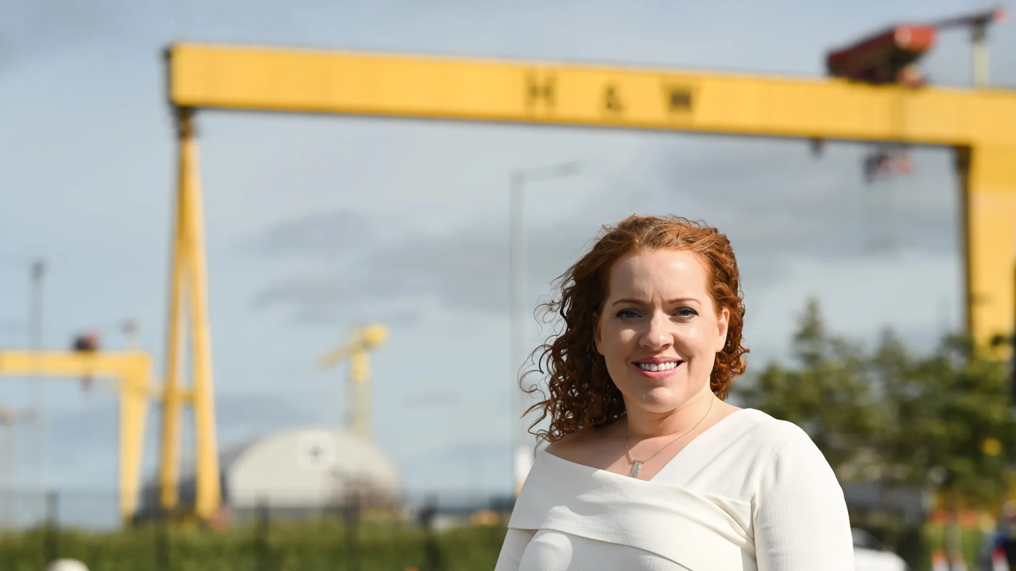 Yvonne McNally with yellow crane and grey sky background