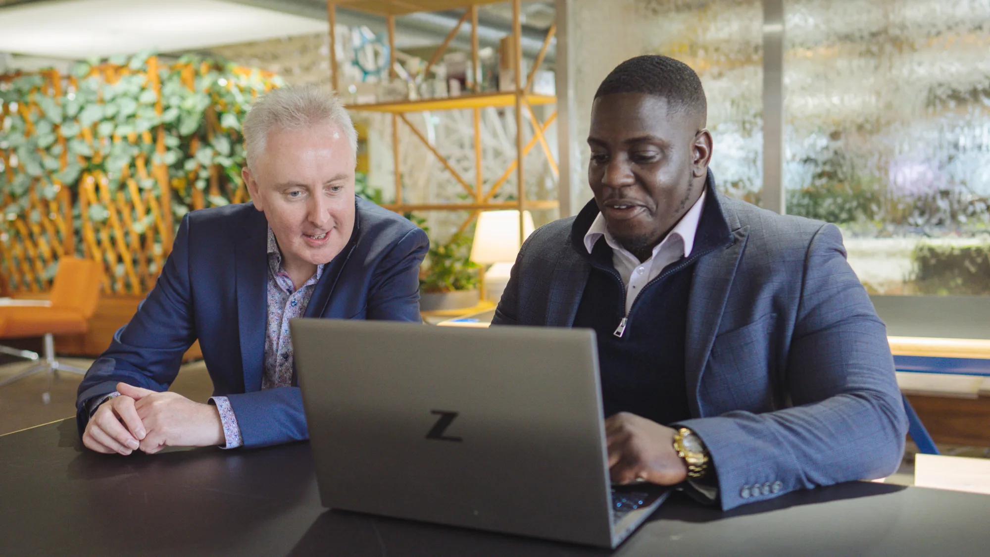 Andrew Parkin in reception area meeting with colleague looking at laptop screen