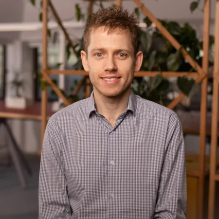 Head and sholders shot of Dan weaing a checked shirt standing in the Birmingham office