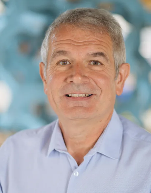 Glyn Hodgkiss in blue shirt with acoustics feature background