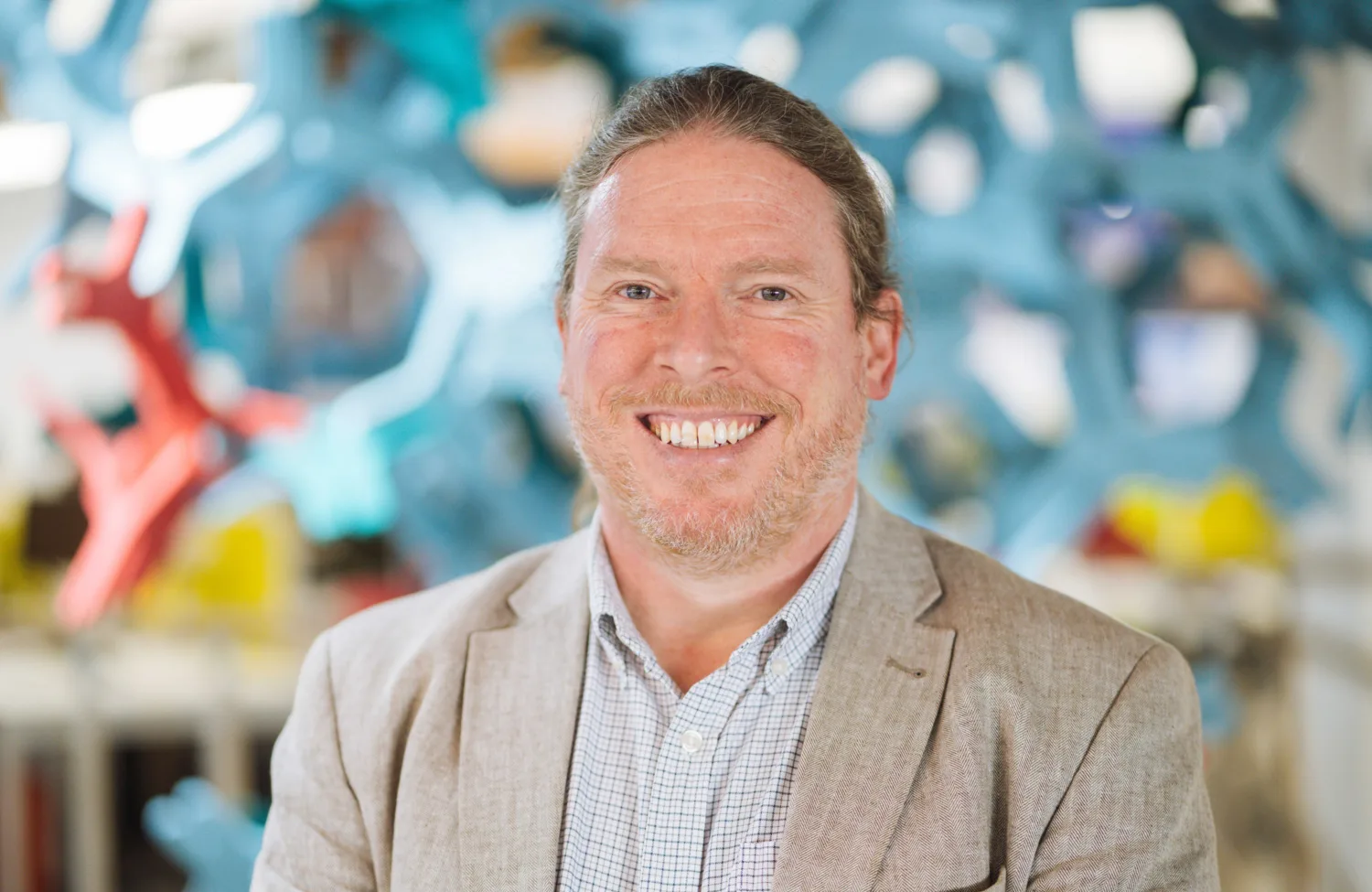Peter Hazzard in beige suit and acoustics feature background