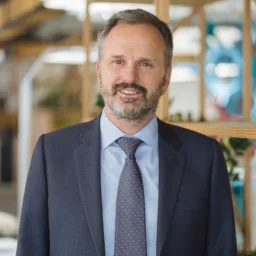 Rob van Zyl in a dark suit and tie with office blurred background
