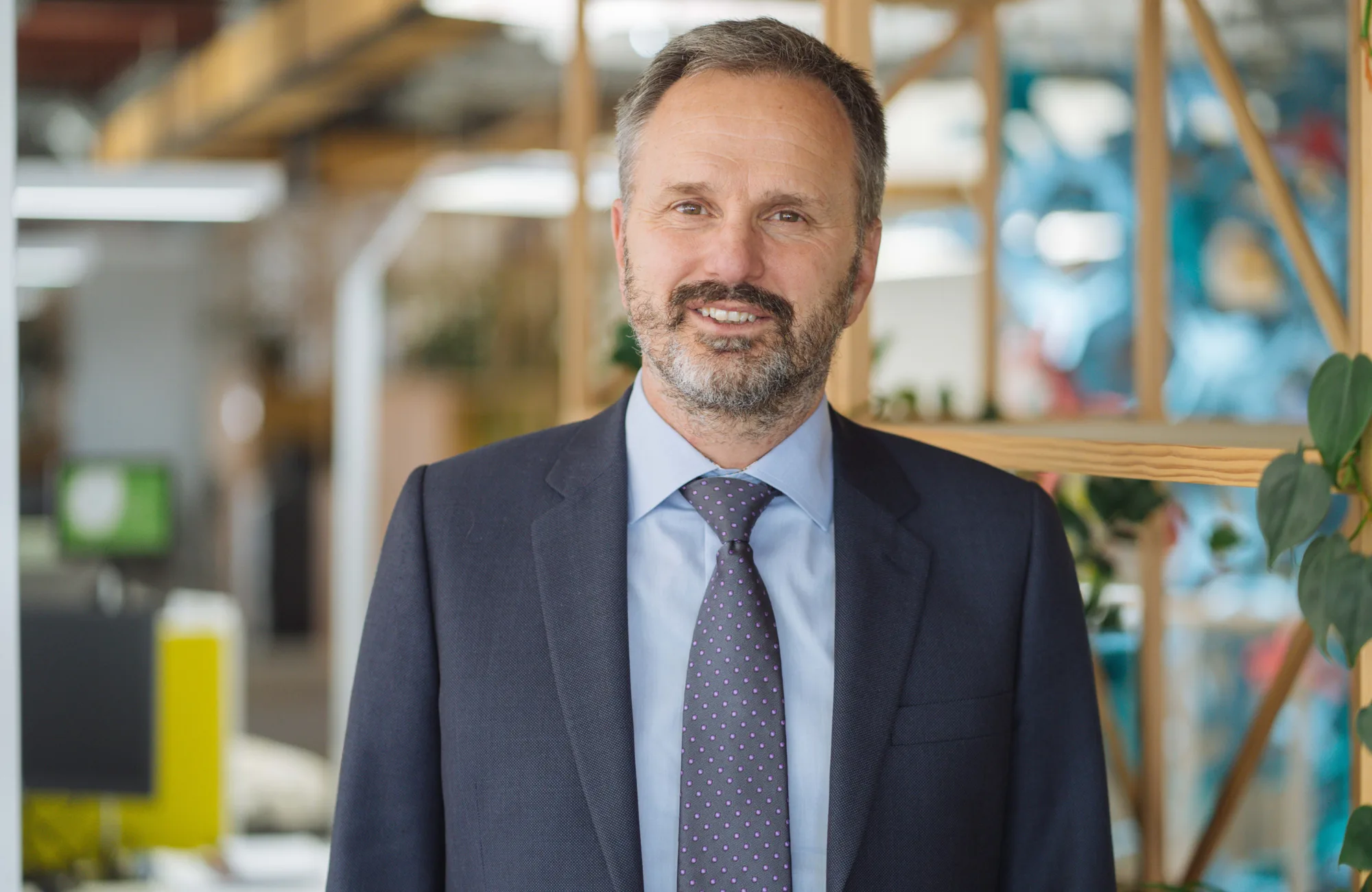 Rob van Zyl in a dark suit and tie with office blurred background