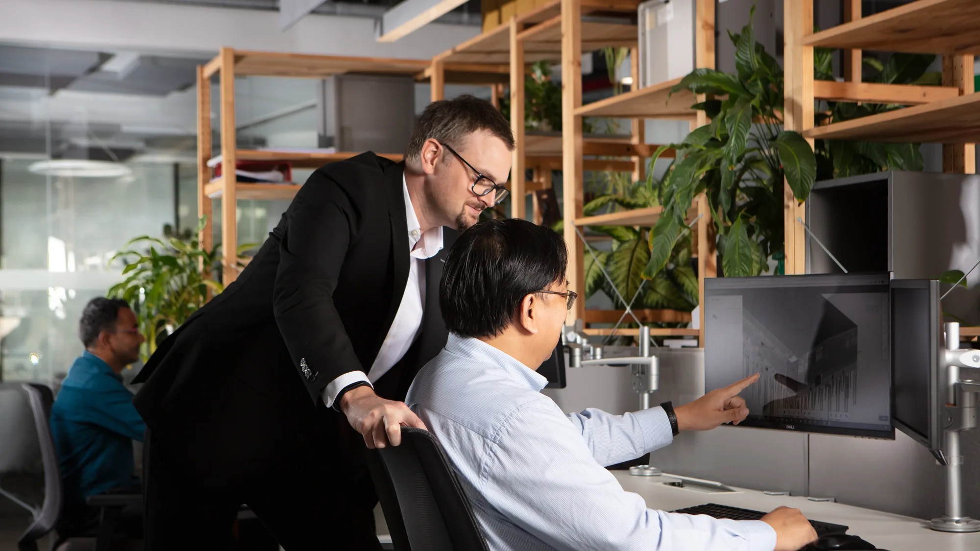 Gary Dodds checking a BIM model with a colleague in front of a computer monitor