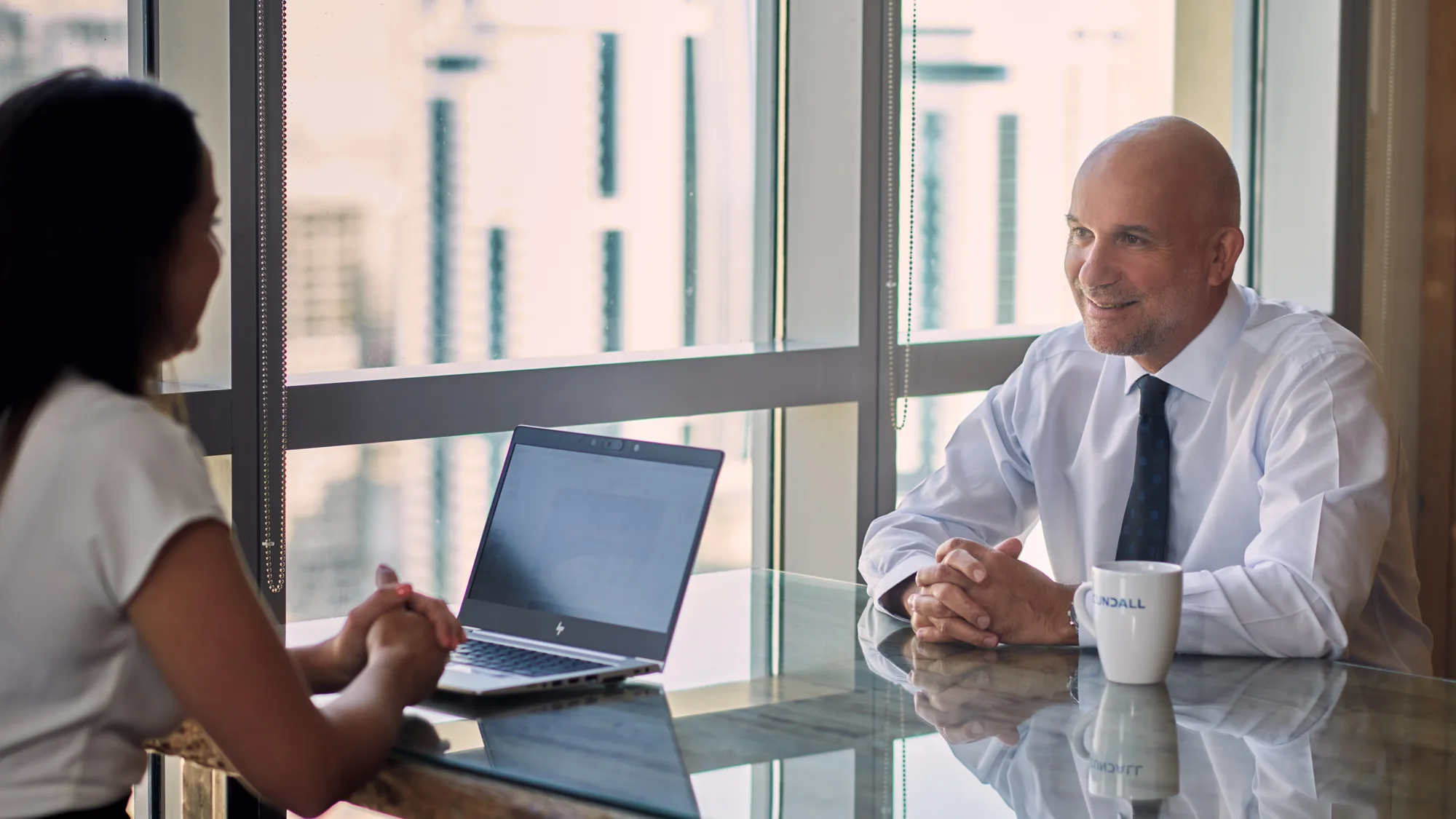 Tony Owens in meeting room with large windows with a collague
