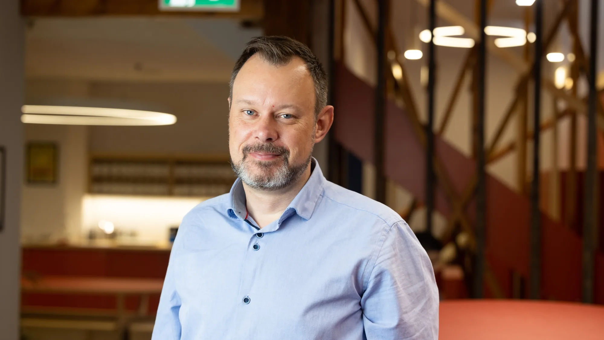Cormac Farrell in a blue shirt with a blurred office background