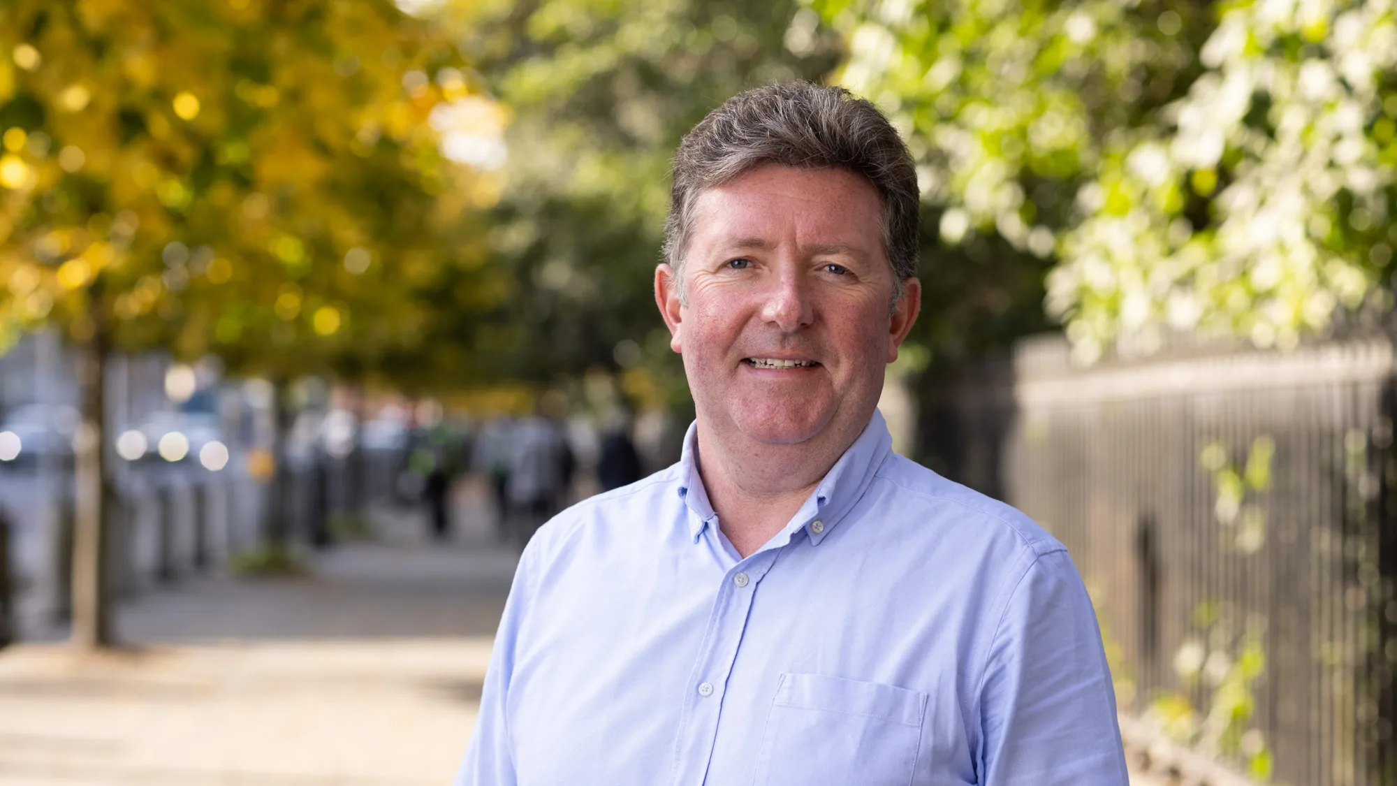 William Dolan standing outside wearing a blue shirt