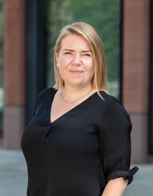Barbara Sacha in front office class and cladded building