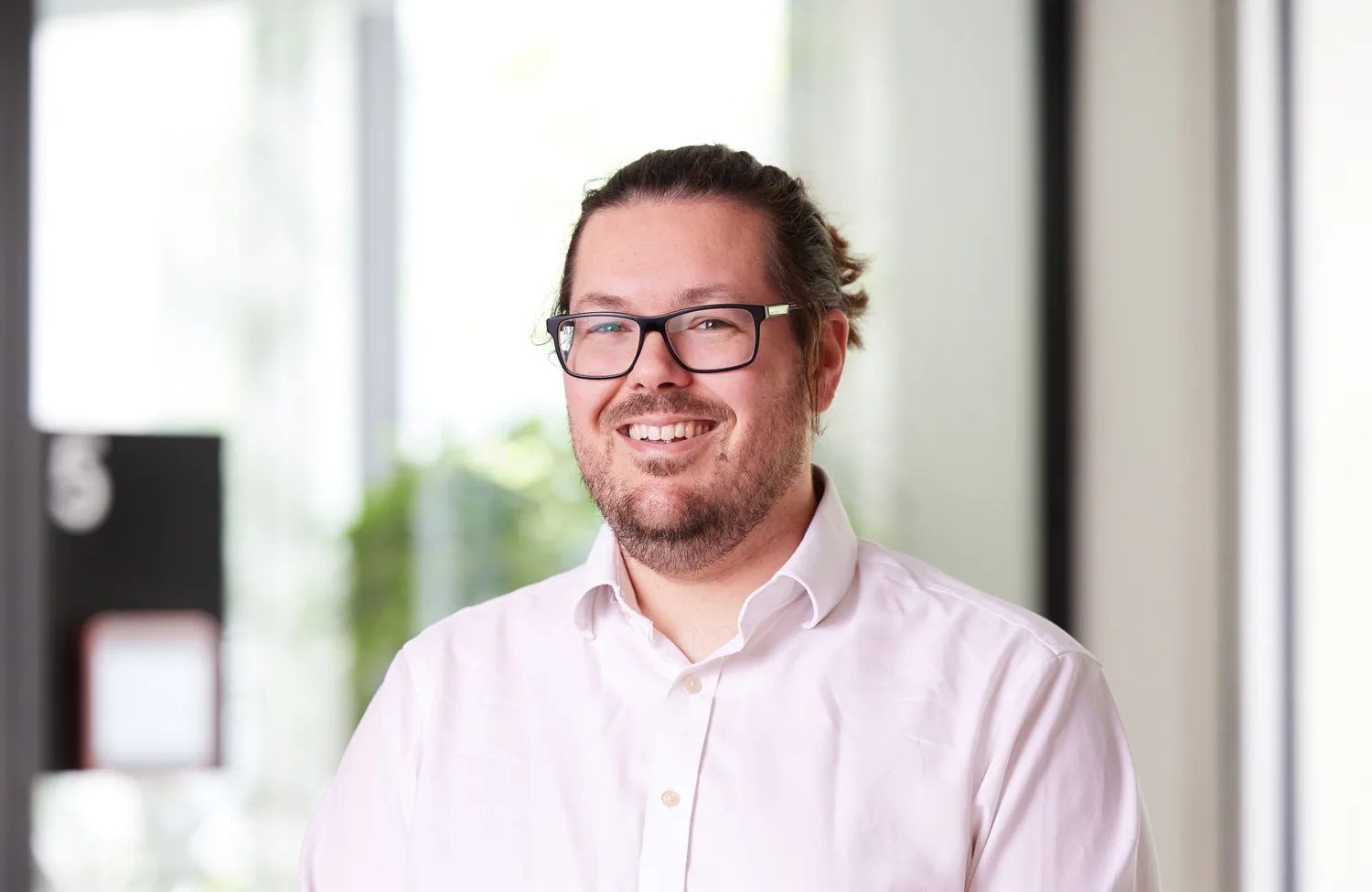 Head and shoulders image of Conrad Stone in an office wearing a white shirt