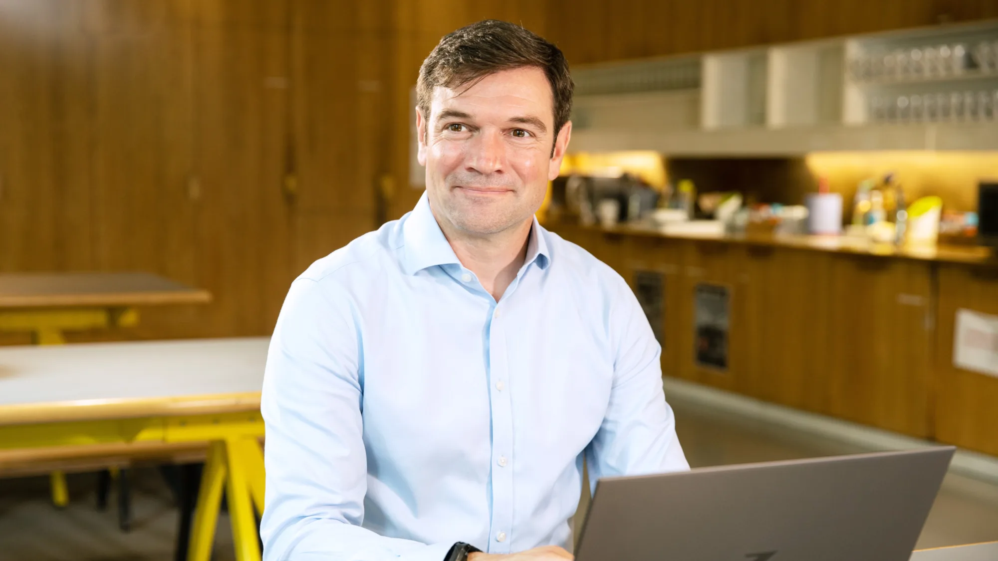 Dan Bennett in kitchen area working on a laptop