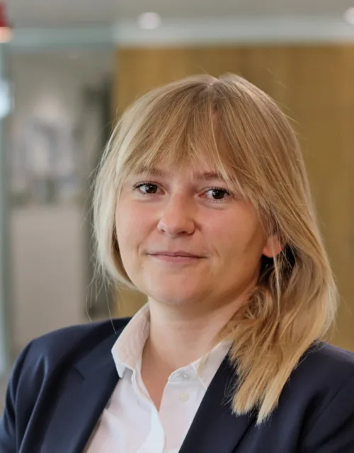 Gosia in a white open collar shirt and dark blue suit jacket