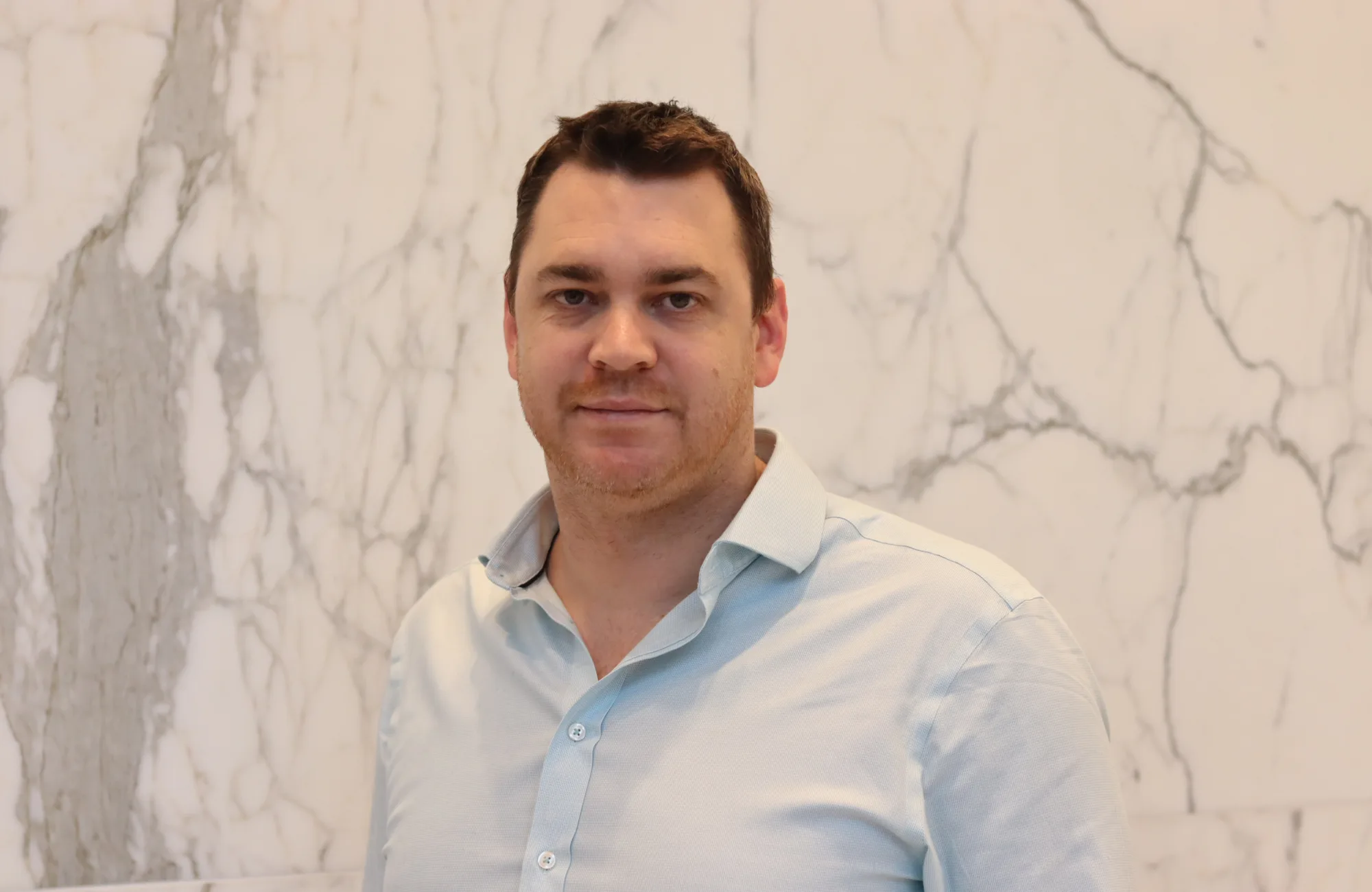 Jamie Cameron looking towards the camera in a light blue shirt