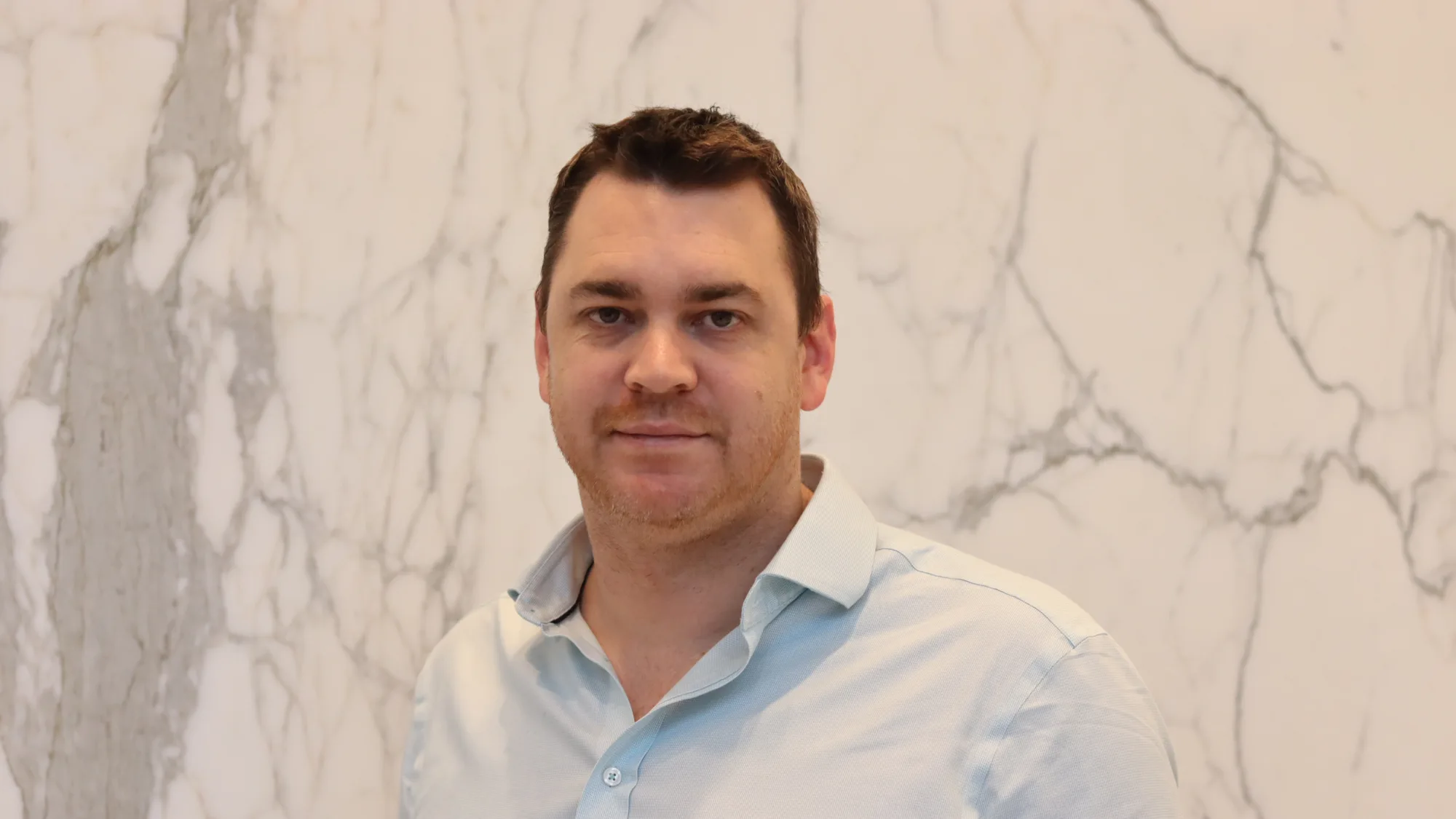 Jamie Cameron looking towards the camera in a light blue shirt