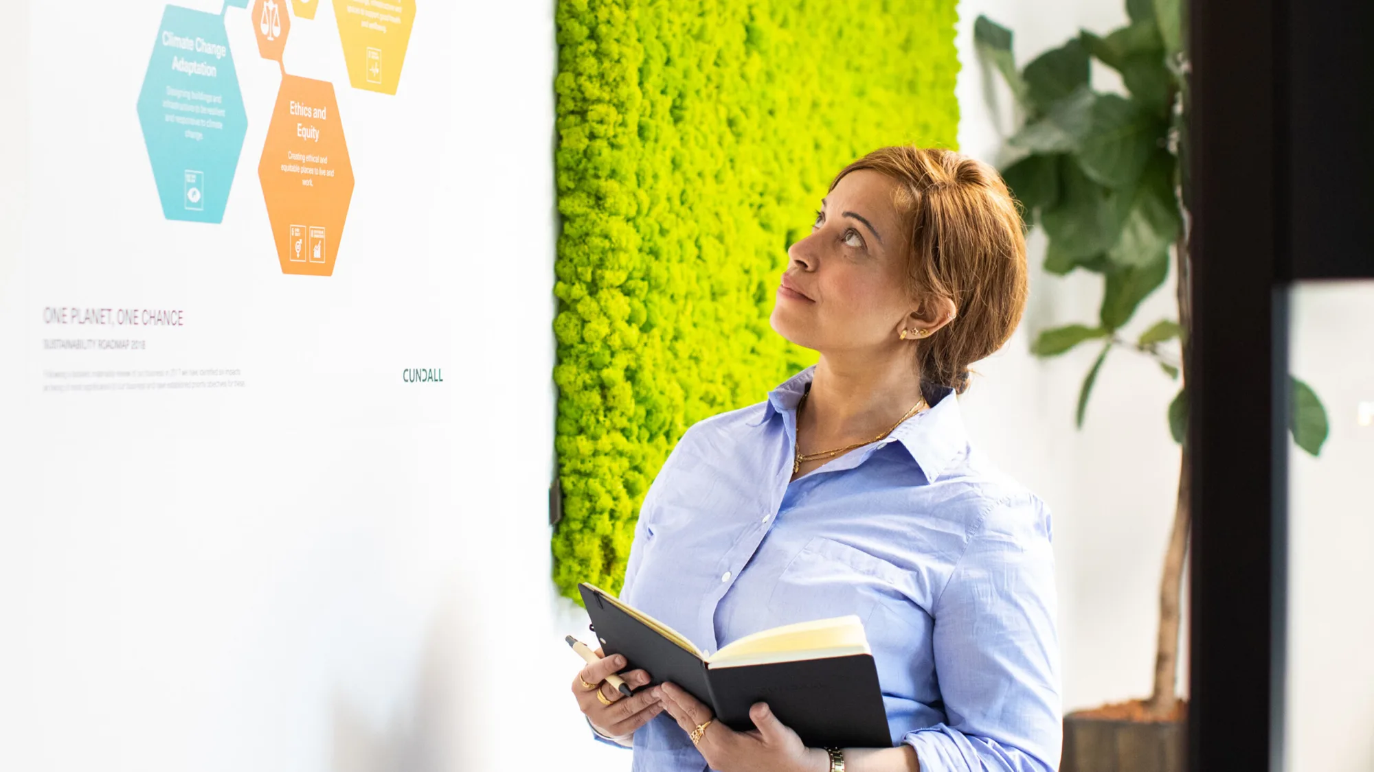 Kavita Kumari in meeting room looking at poster on wall