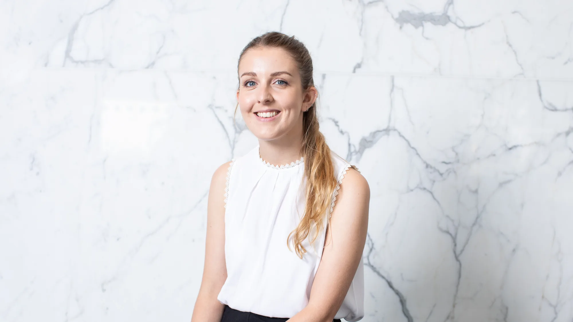 Lauren Davies in a white top with a marble background