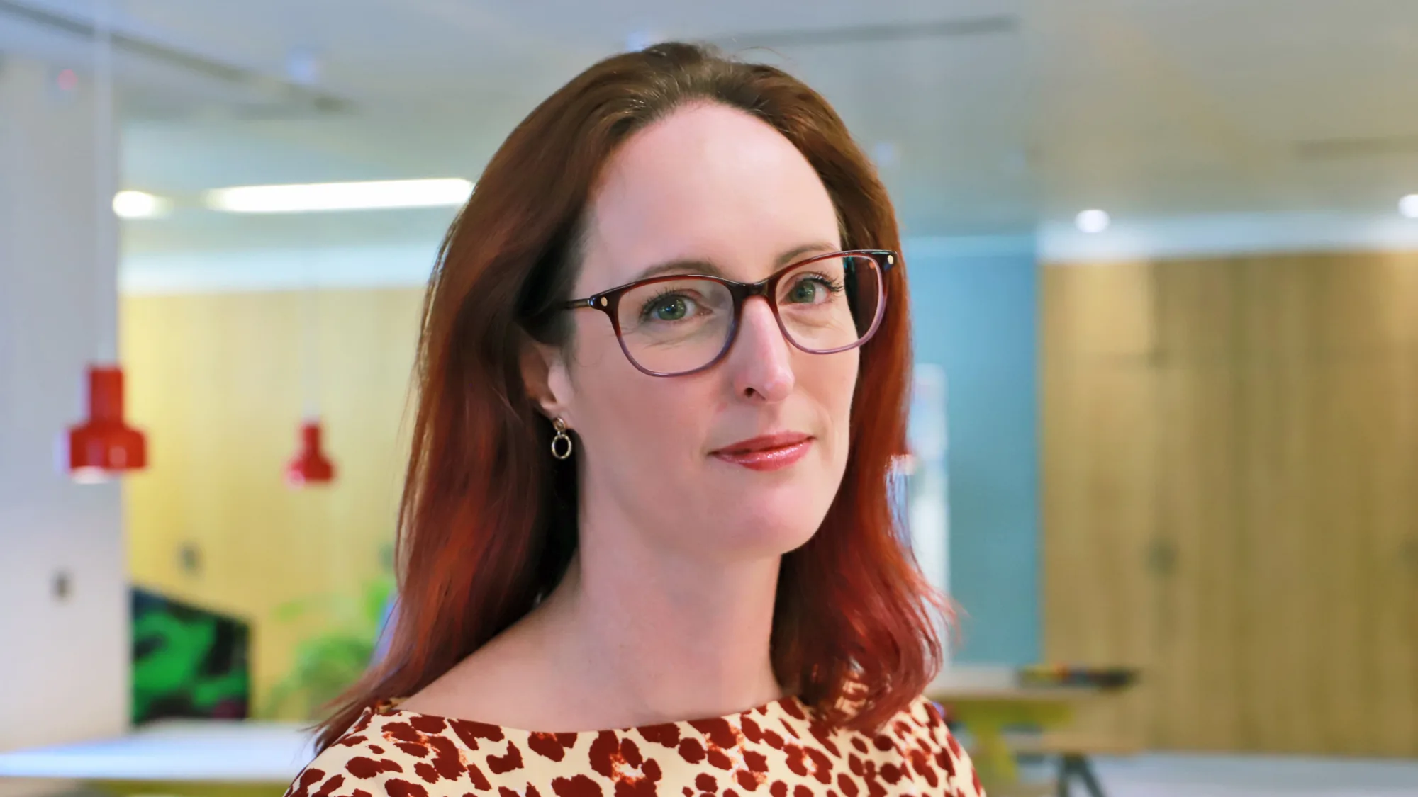 Leigh Harper looking at the camera with an office back drop