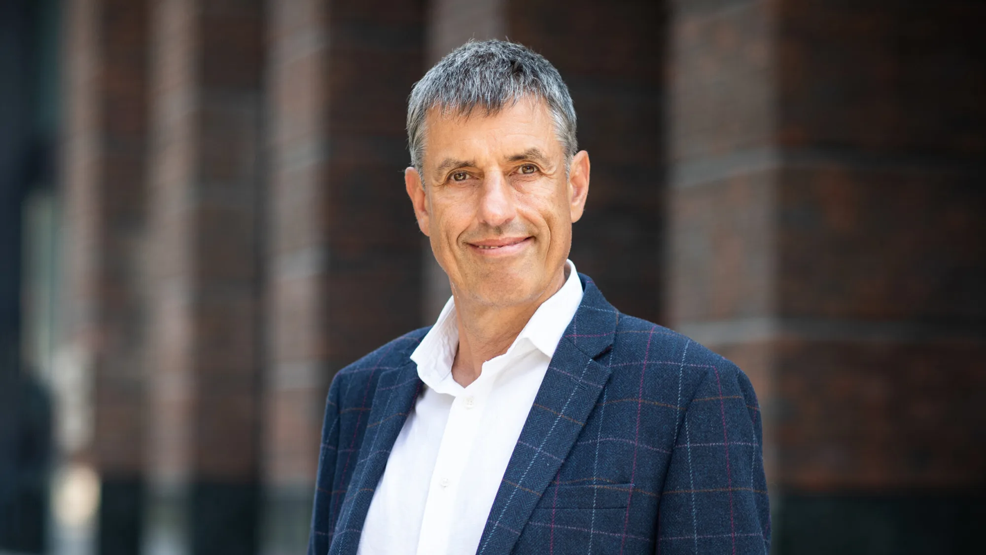 Peter Stocks in front of office in a dark suit and white shirt
