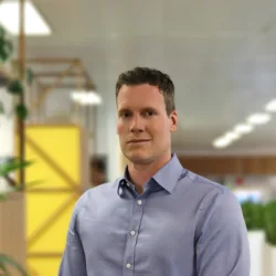 Rob standing in front of plants in London office