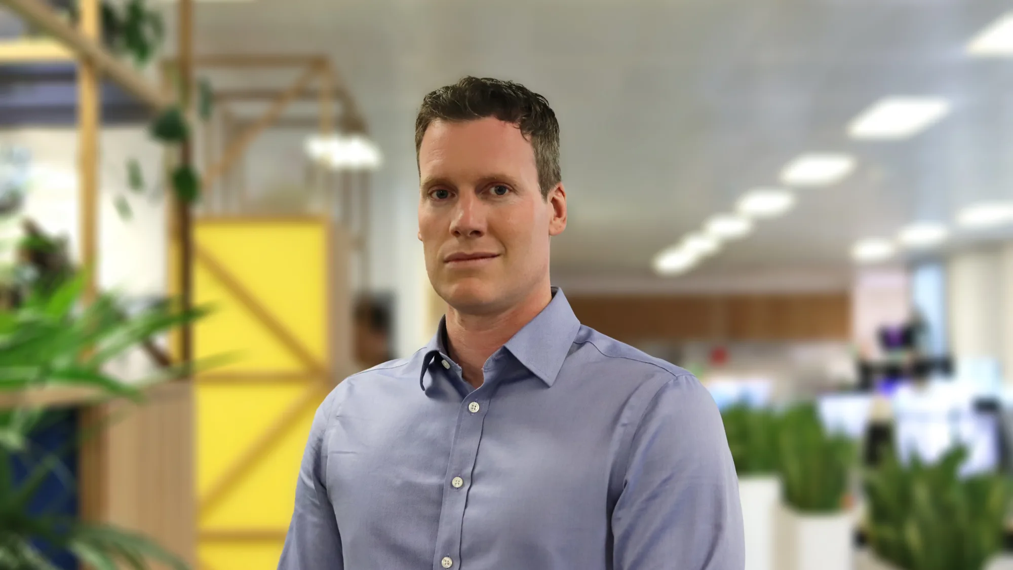 Rob standing in front of plants in London office