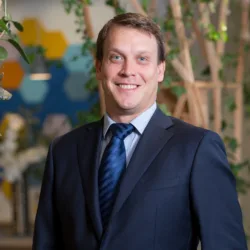 Head and sholders image of Robin in suit tie and jacket standing in the London office
