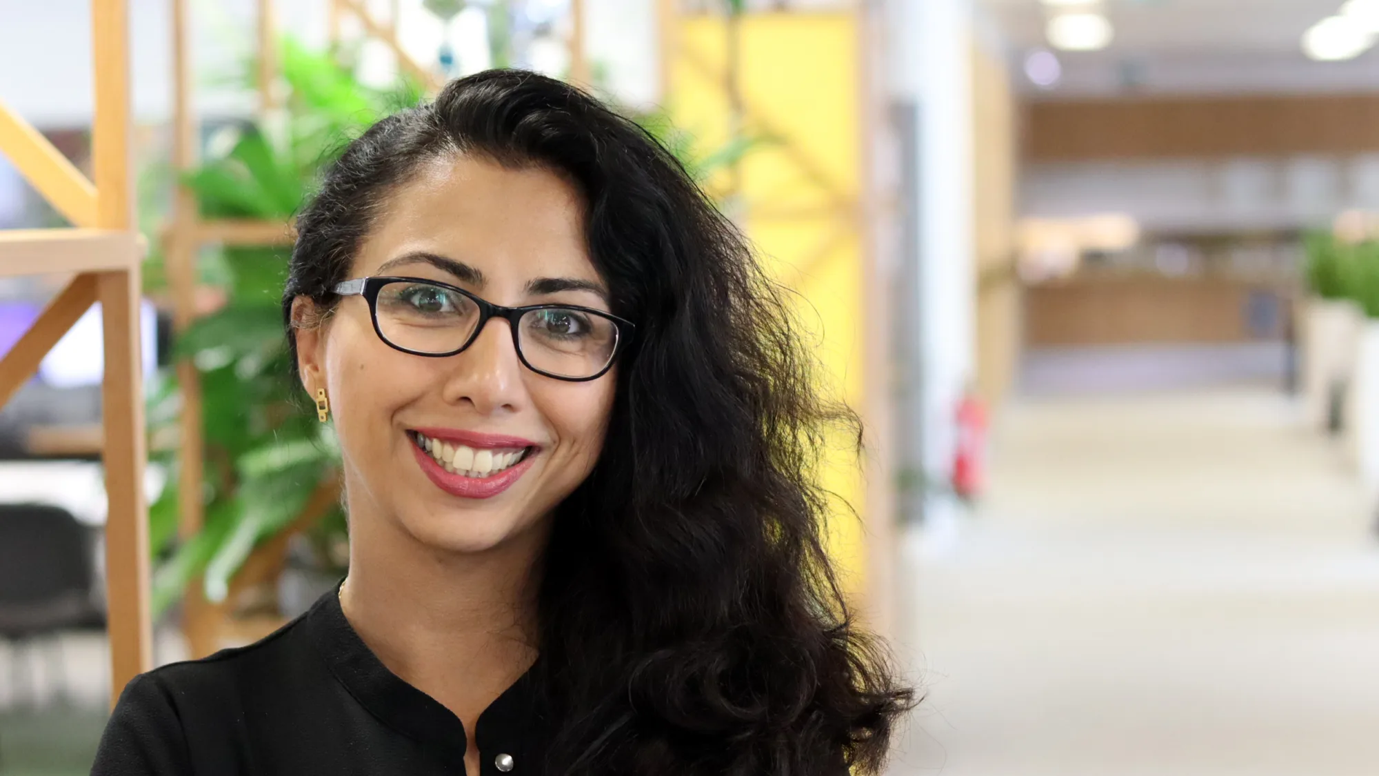 Roxana smiling to camera stood in an office space