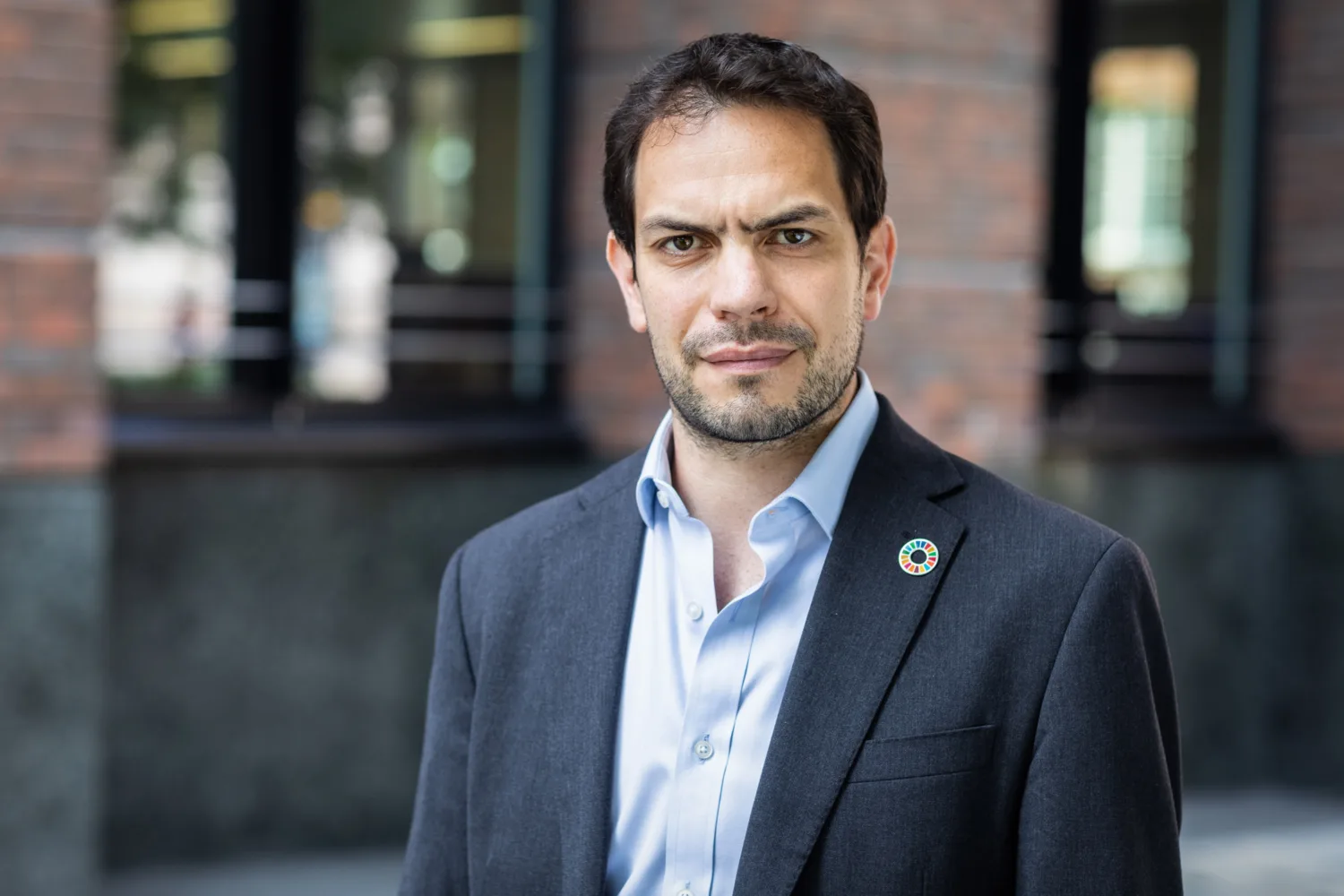 Simon Wyatt in front of office facade in a dark suit and blue shirt