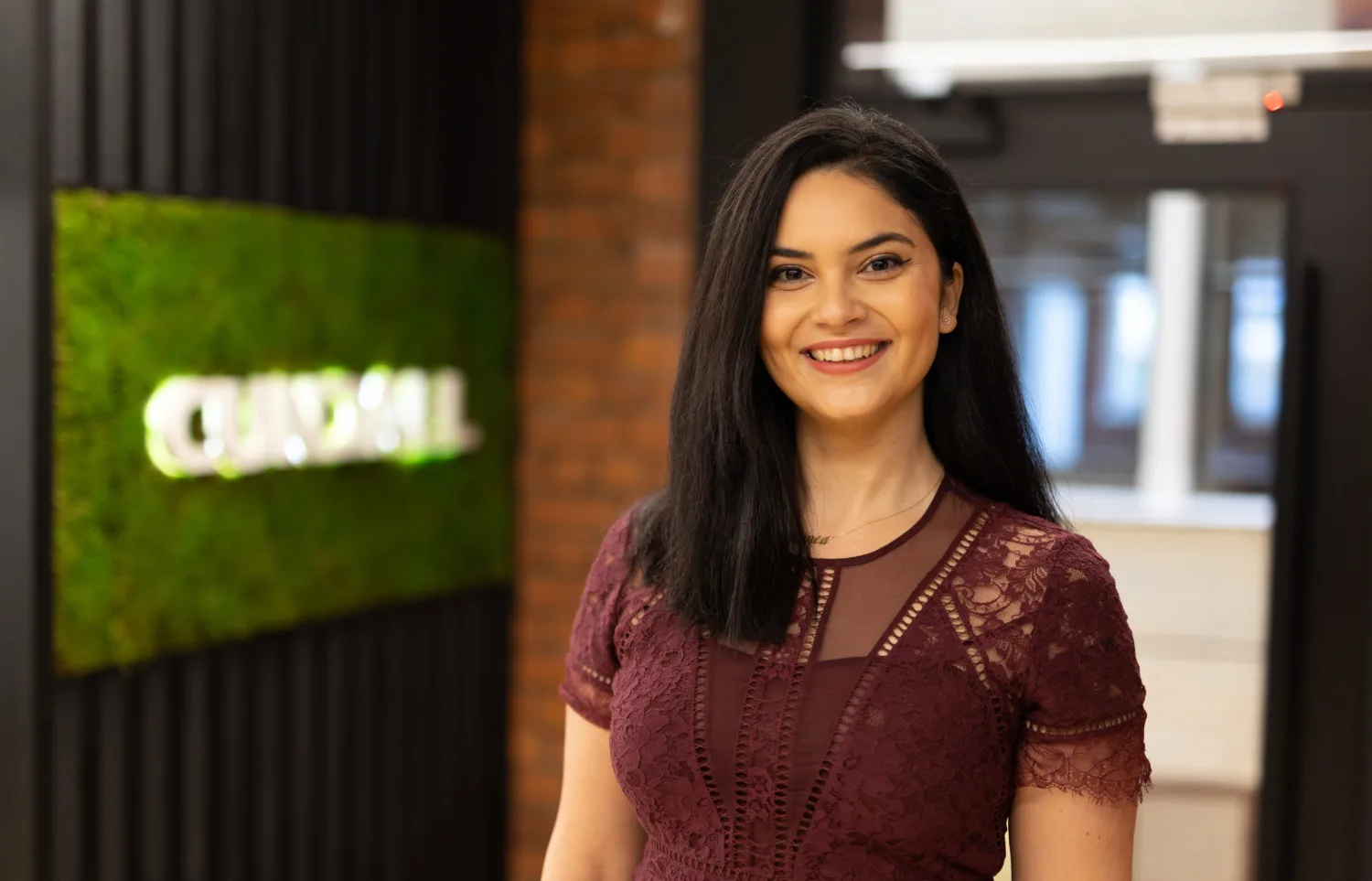 Bianca Spoeala in red dress with office background